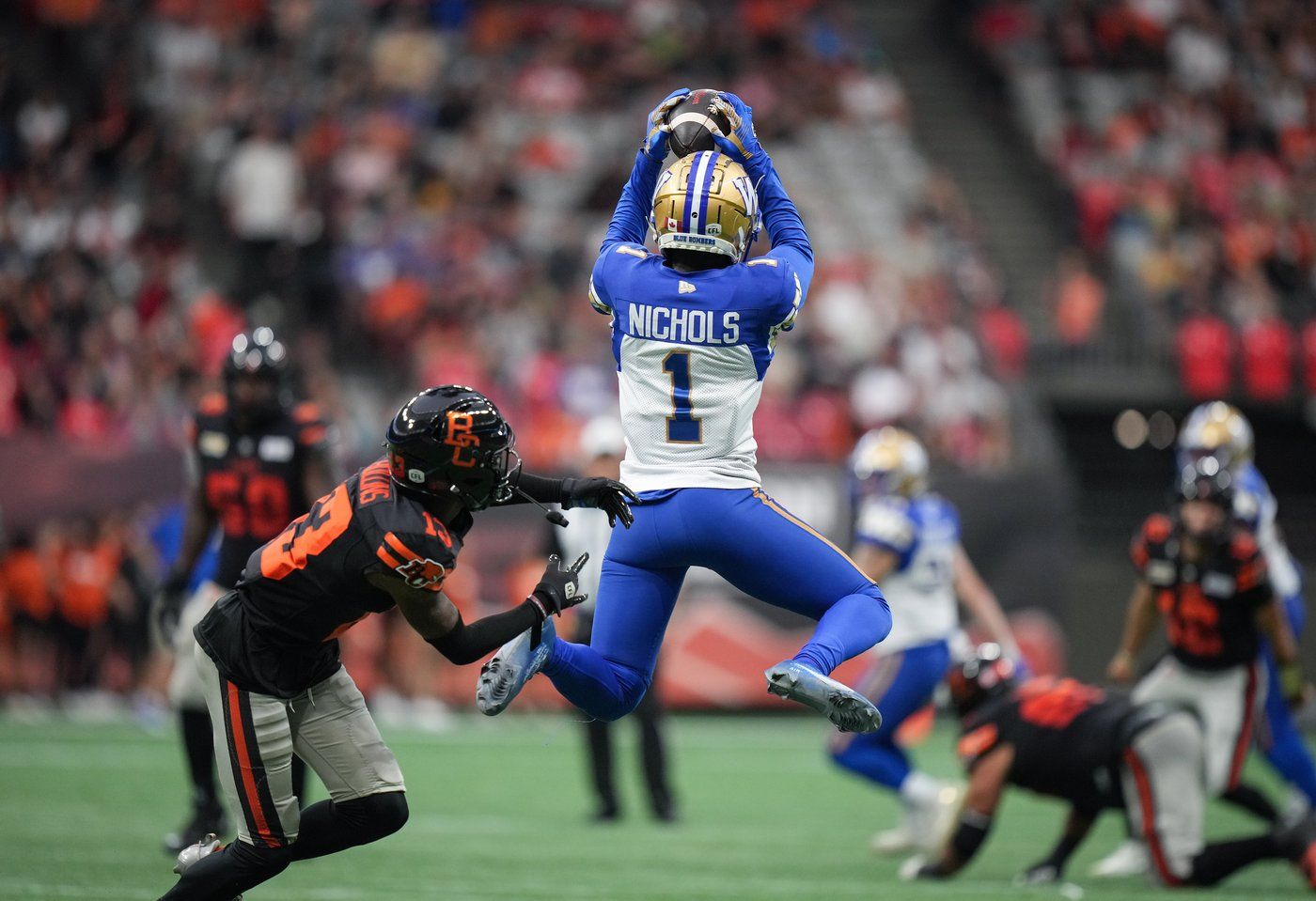 Winnipeg Blue Bombers' Deatrick Nichols (1) intercepts a pass intended for B.C. Lions' Alexander Hollins (13) during the first half of a CFL football game, in Vancouver, B.C., Sunday, Aug. 18, 2024. THE CANADIAN PRESS/Darryl Dyck