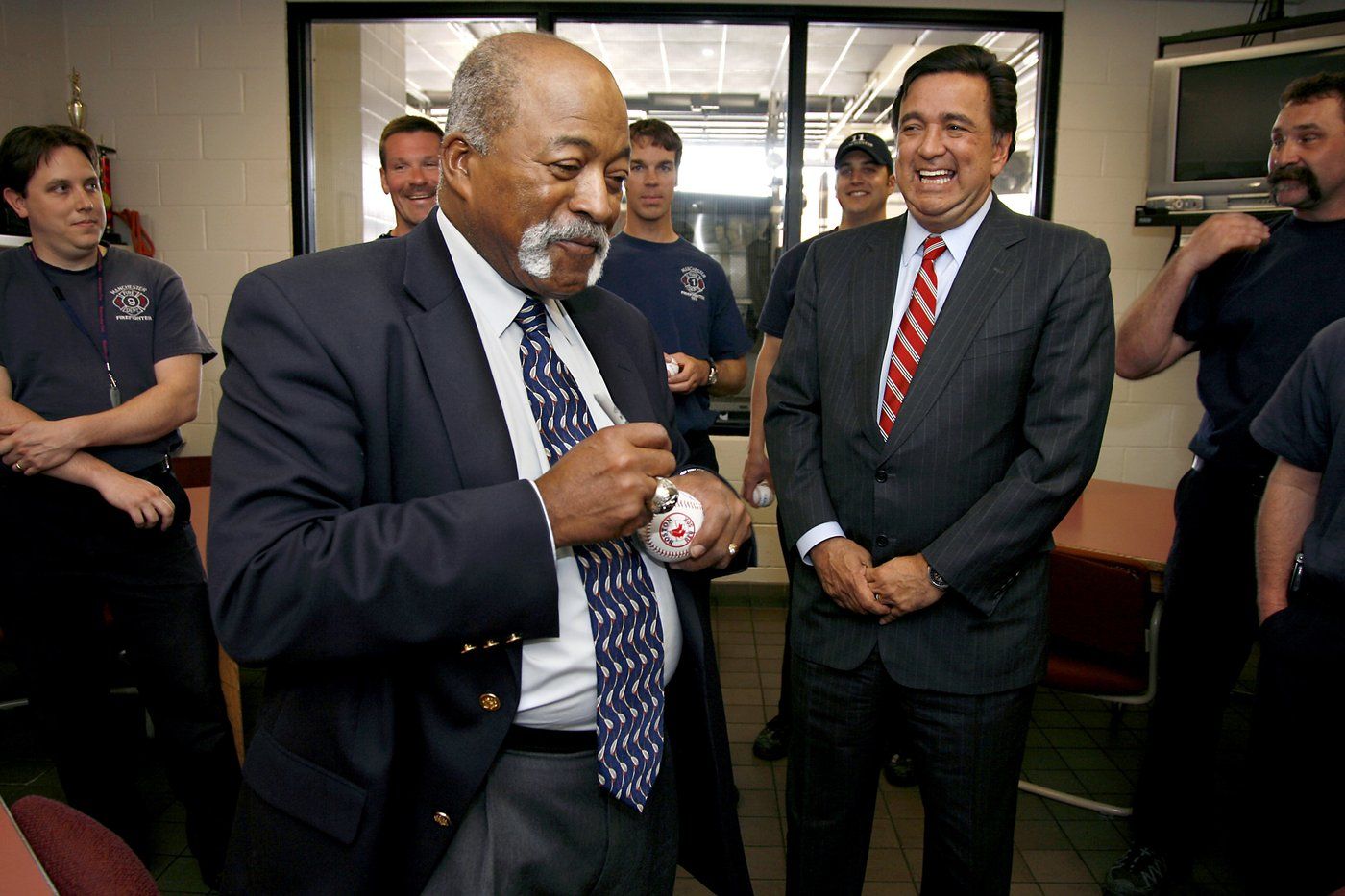 FILE - Former major league baseball player Luis Tiant signs baseballs for firefighters at the Manchester Fire Department in Manchester, N.H., as presidential hopeful, New Mexico Gov. Bill Richardson, right, watches, Monday, May 7, 2007. (AP Photo/Cheryl Senter, File)