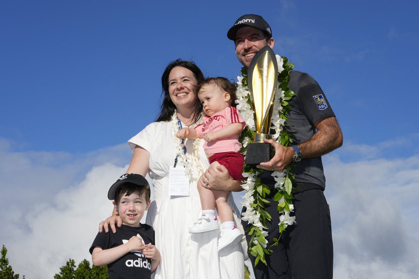 Nick Taylor, right, of Canada, poses with his wife, Andie Taylor, and his children, Charlie Taylor, left, and Harper Taylor, centre, after winning the Sony Open golf event, Sunday, Jan. 12, 2025, at Waialae Country Club in Honolulu. (AP Photo/Matt York)