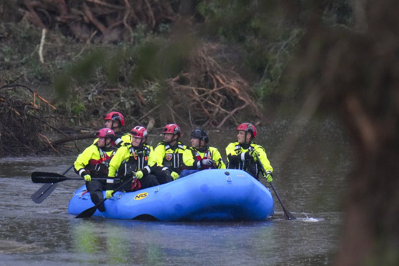 Officials ride a boat as they arrive to assist with a recovery effort at Camp Mystic along the Guadalupe River after a flash flood swept through the area Sunday, July 6, 2025, in Hunt, Texas. (AP Photo/Julio Cortez)
