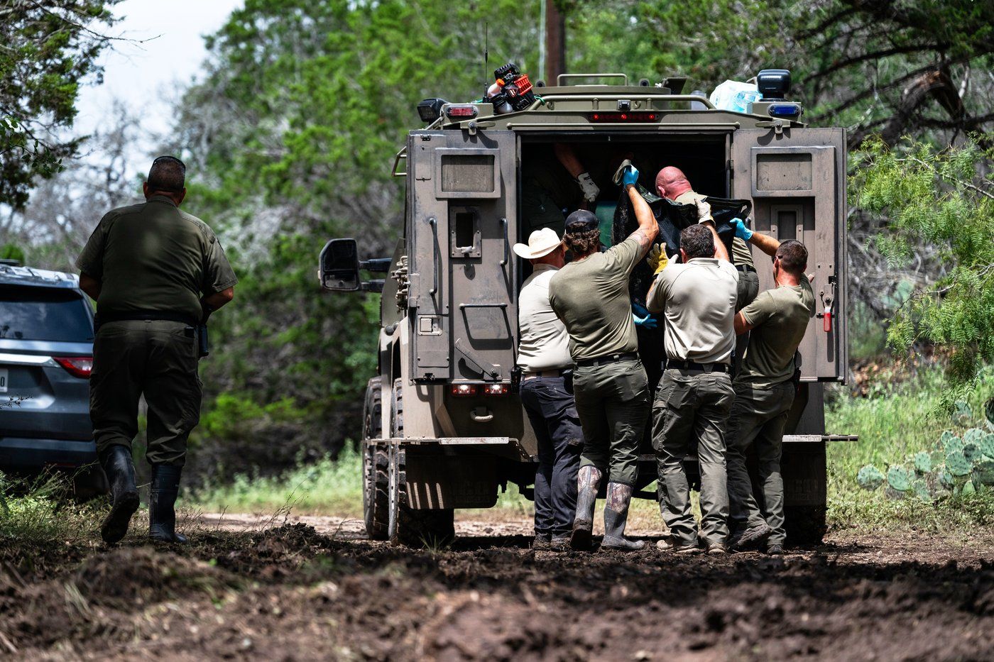 Texas Department of Public Safety Troopers load a recovered body into the back of a vehicle near the Guadalupe River after a flash flood swept through the area, Monday, July 7, 2025, in Ingram, Texas. (AP Photo/Eli Hartman)