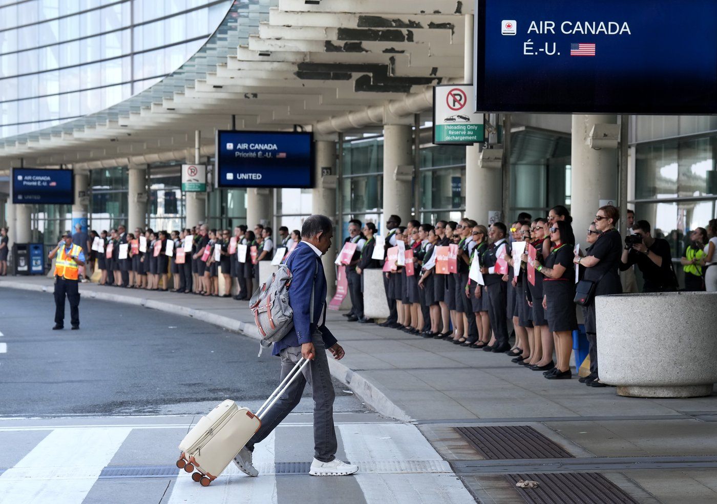 Air Canada flight attendants gather for a demonstration in preparation for a possible strike at Pearson International Airport in Toronto, on Monday, Aug. 11, 2025. THE CANADIAN PRESS/Nathan Denette